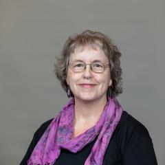 Headshot of staff with grey background