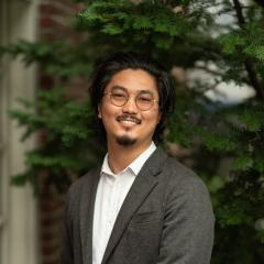 Headshot image of staff with greenery background