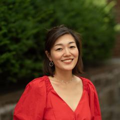 Headshot of staff with greenery and brick background