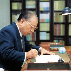 Daisaku Ikeda writing at desk