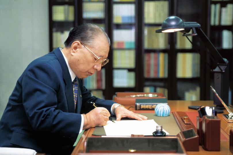 Daisaku Ikeda writing at desk