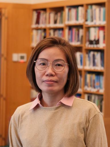Headshot image of staff with bookshelves background