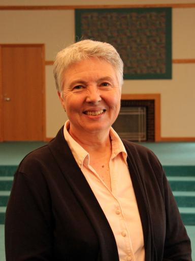 Headshot image of staff with a green-colored stage in the background