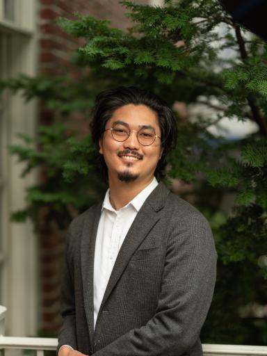 Headshot image of staff with greenery background