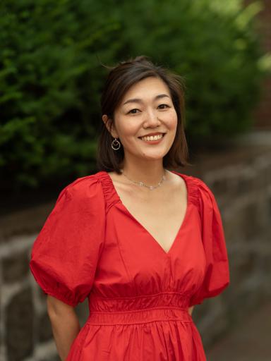Headshot of staff with greenery and brick background