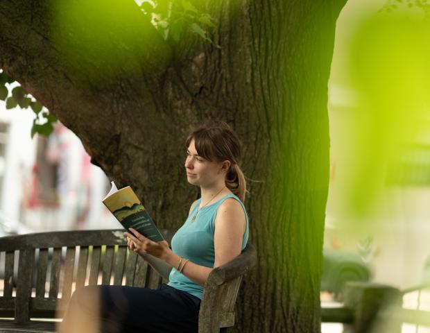 Program intern Becca Faber modeling with Ikeda Center book