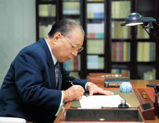 Daisaku Ikeda writing at desk